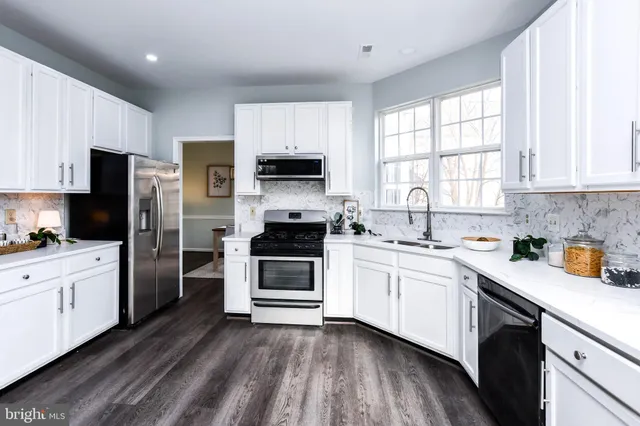 a kitchen with granite countertop white cabinets and white appliances