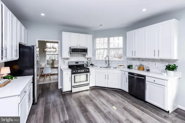 a kitchen with a sink a window and cabinets