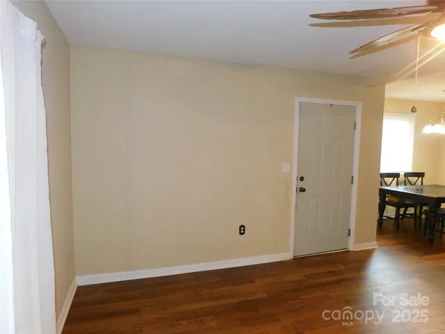 a view of a room with wooden floor and a window