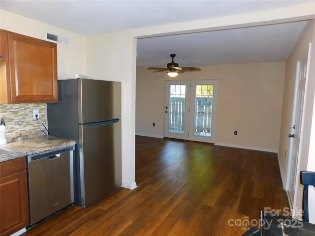 a kitchen with a refrigerator and a stove top oven