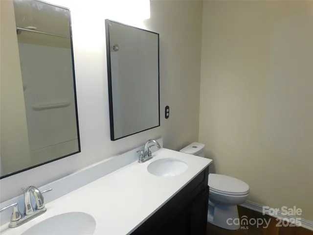 a bathroom with a sink vanity mirror and toilet