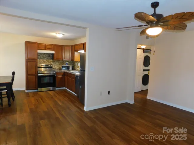 a kitchen with granite countertop stainless steel appliances and wooden floor