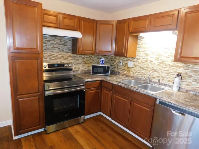 a kitchen with granite countertop stainless steel appliances and wooden cabinets