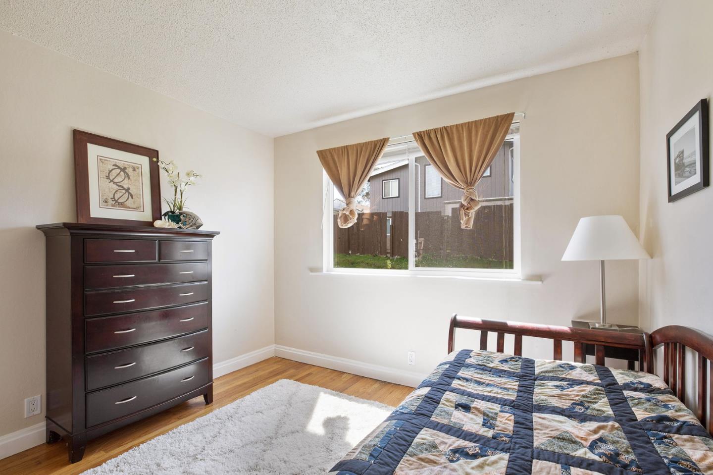 644 Foothill Drive Pacifica, CA 94044 - Photo 11 of 15 a bedroom with a bed and a lamp on dresser