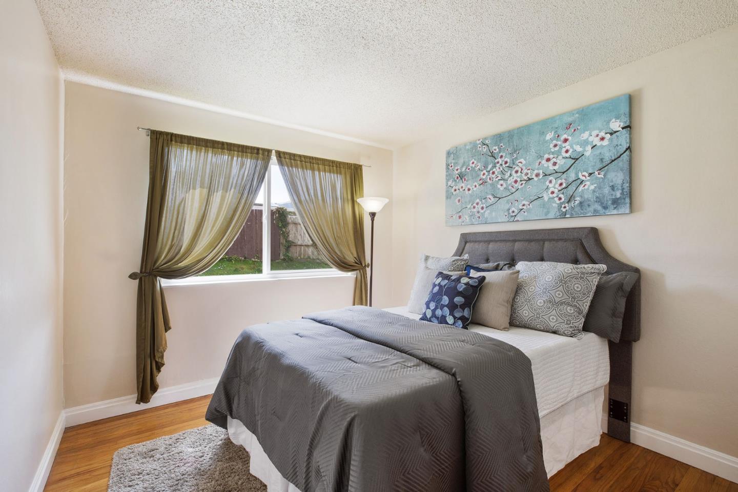 644 Foothill Drive Pacifica, CA 94044 - Photo 8 of 15 a bedroom with a bed and a painting on the wall