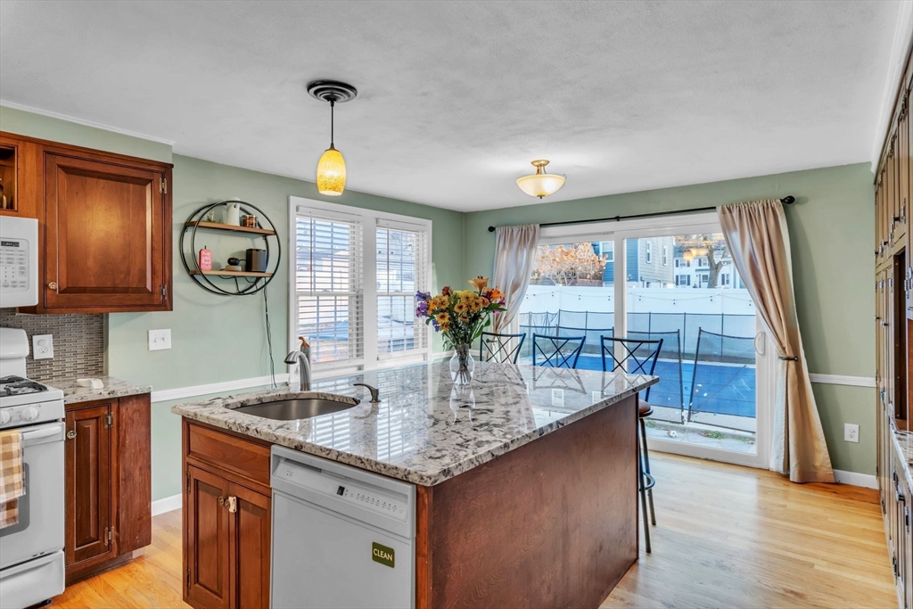 39 Hartwick Street Springfield, MA 01108 - Photo 5 of 37 a kitchen with granite countertop sink and wooden cabinets