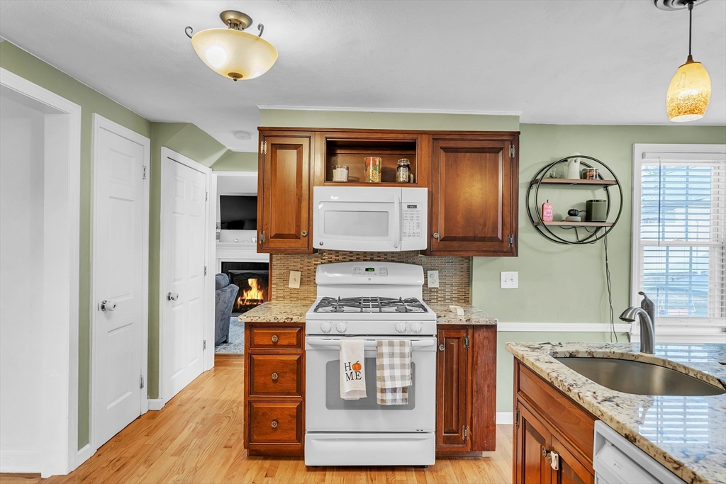 39 Hartwick Street Springfield, MA 01108 - Photo 8 of 37 a kitchen with stainless steel appliances granite countertop a sink and a stove with wooden floor