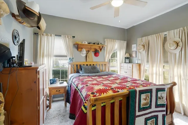 a bedroom with a bed a dresser and a chandelier