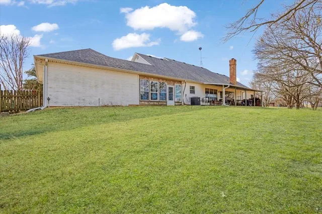 a view of a house with a big yard and large trees