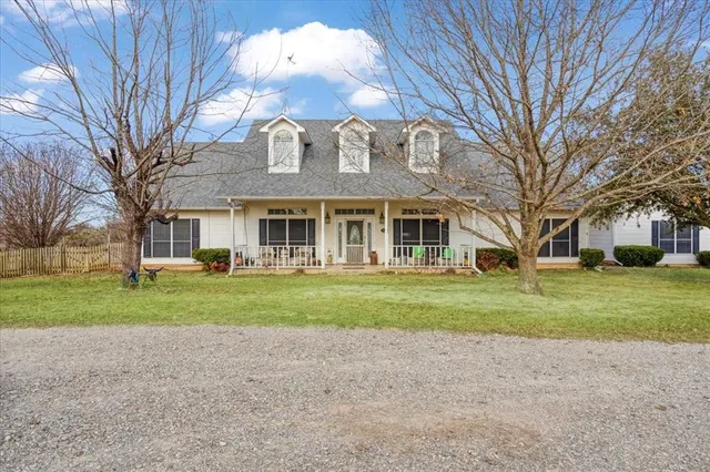 a view of a big house with a big yard and large trees