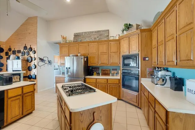 a kitchen with stainless steel appliances granite countertop a stove a sink and a refrigerator