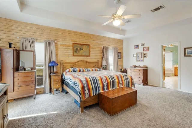 a spacious bedroom with a bed and a chandelier