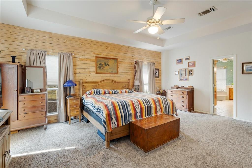 1044 County Road 3230 Windom, TX 75492 - Photo 9 of 40 a spacious bedroom with a bed and a chandelier