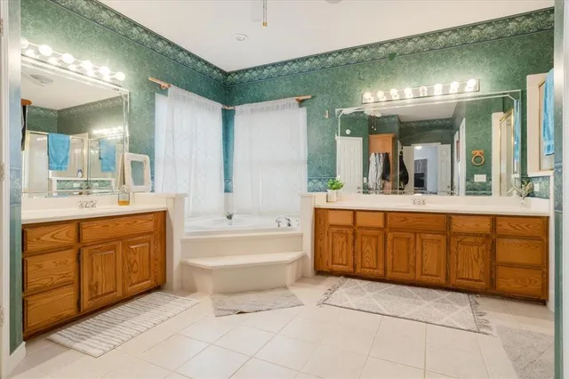 a bathroom with a granite countertop sink mirror and bathtub