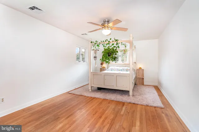 a view of a room with wooden floor and ceiling fan