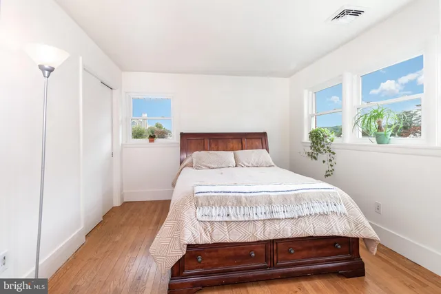 a bedroom with a bed window and wooden floor