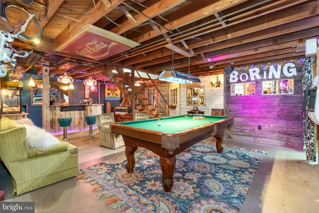 a room with pool table and a wooden floor
