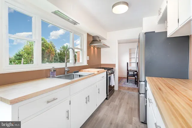 a spacious bathroom with a double vanity sink a mirror and a shower