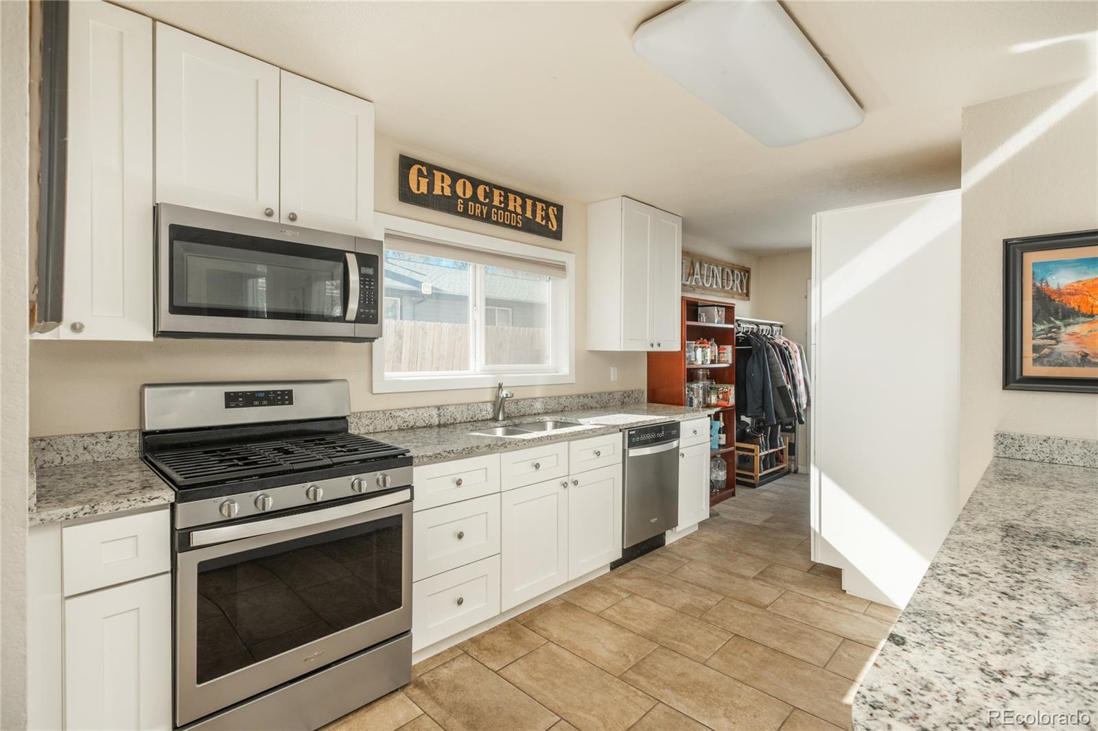 4695 Parfet Street Wheat Ridge, CO 80033 - Photo 12 of 46 a kitchen with granite countertop cabinets stainless steel appliances and a counter space
