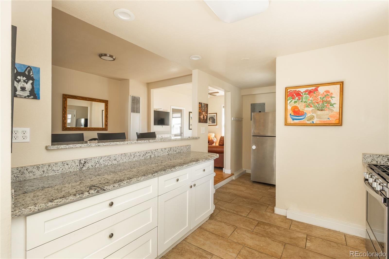 4695 Parfet Street Wheat Ridge, CO 80033 - Photo 13 of 46 a spacious bathroom with a granite countertop sink and a mirror