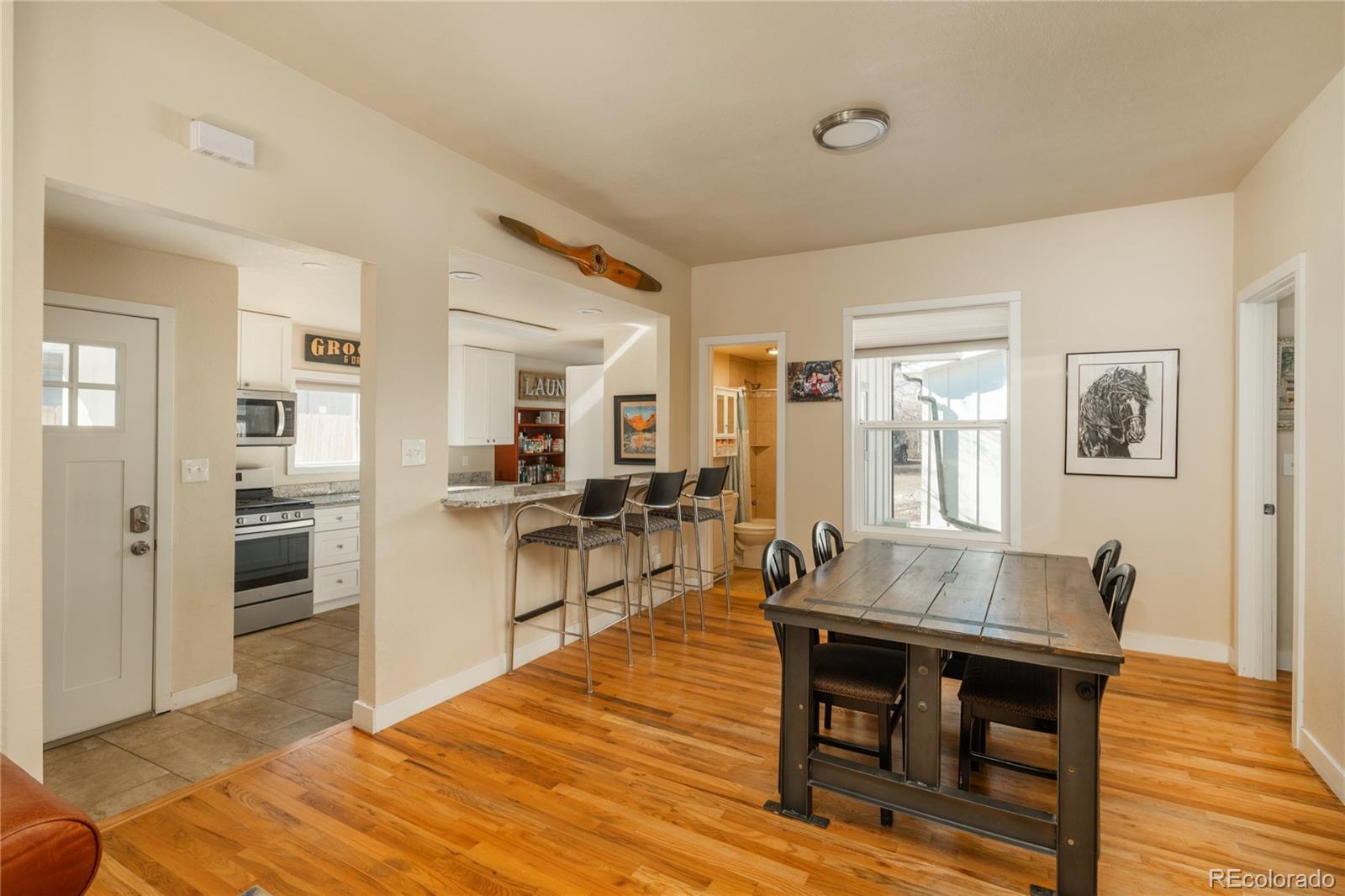 4695 Parfet Street Wheat Ridge, CO 80033 - Photo 24 of 46 a living room with furniture a wooden floor and next to a window