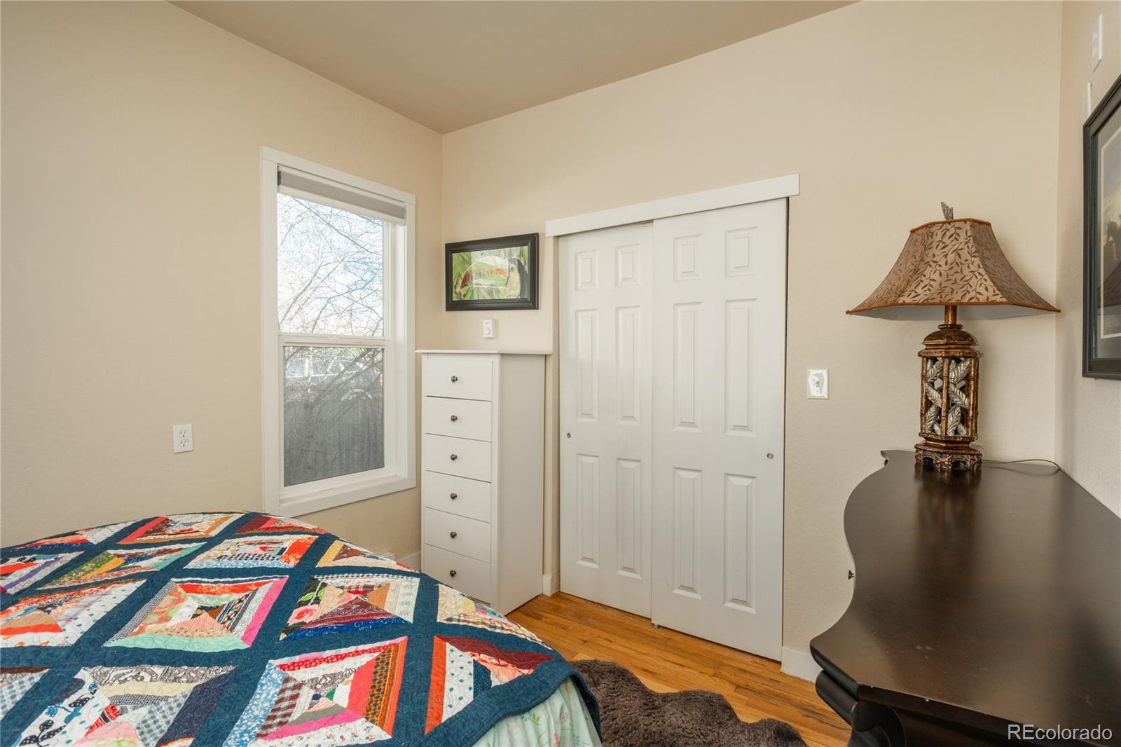 4695 Parfet Street Wheat Ridge, CO 80033 - Photo 26 of 46 a bedroom with a bed and a chandelier