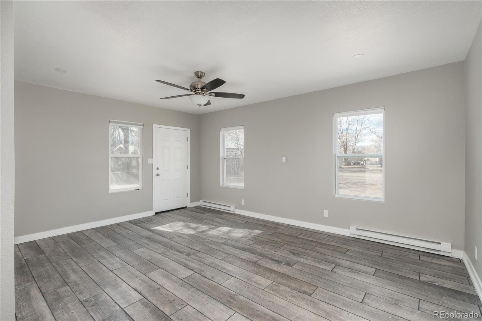 4695 Parfet Street Wheat Ridge, CO 80033 - Photo 30 of 46 a view of an empty room with window and wooden floor
