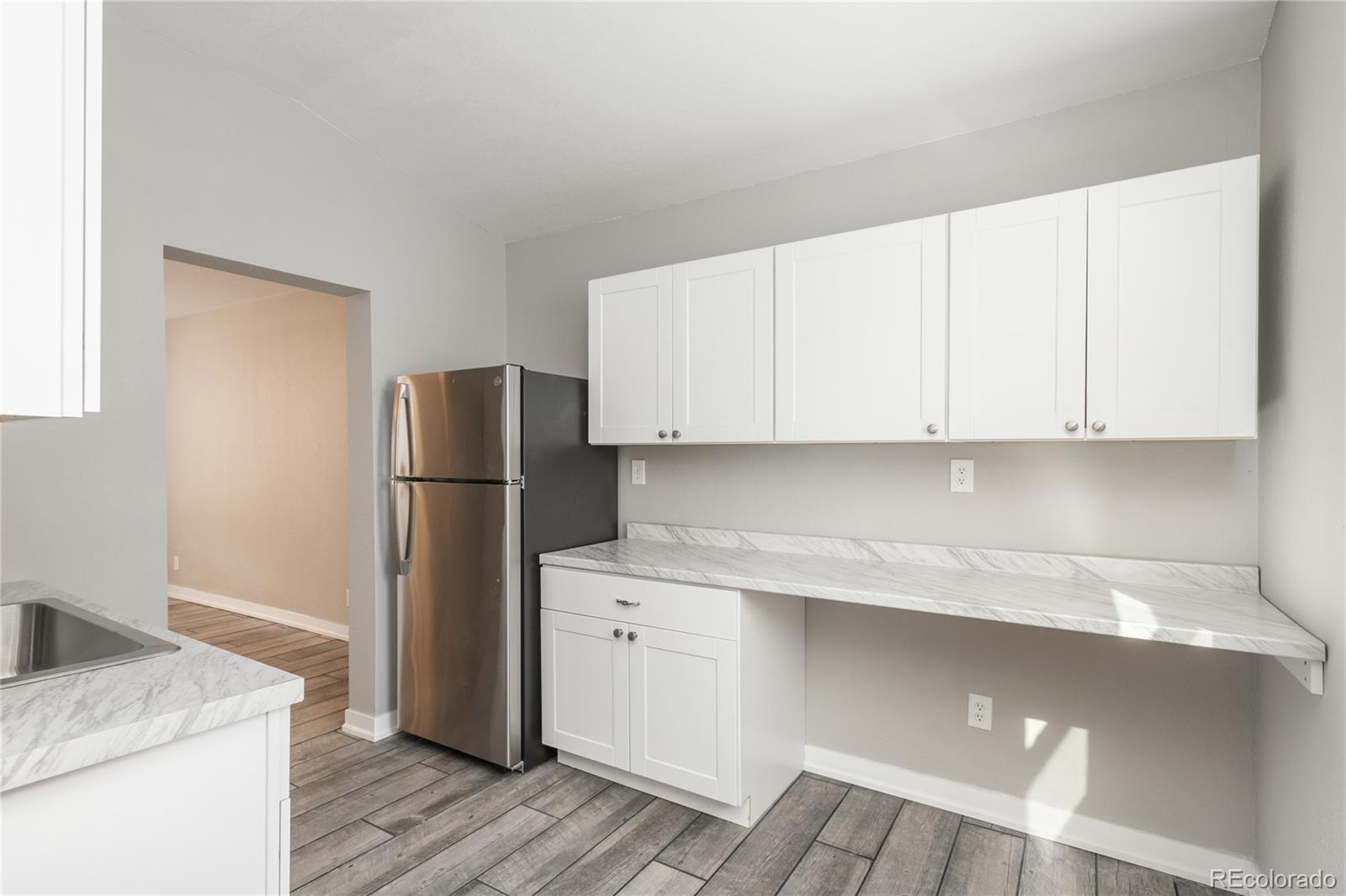 4695 Parfet Street Wheat Ridge, CO 80033 - Photo 32 of 46 a kitchen with a refrigerator sink and cabinets