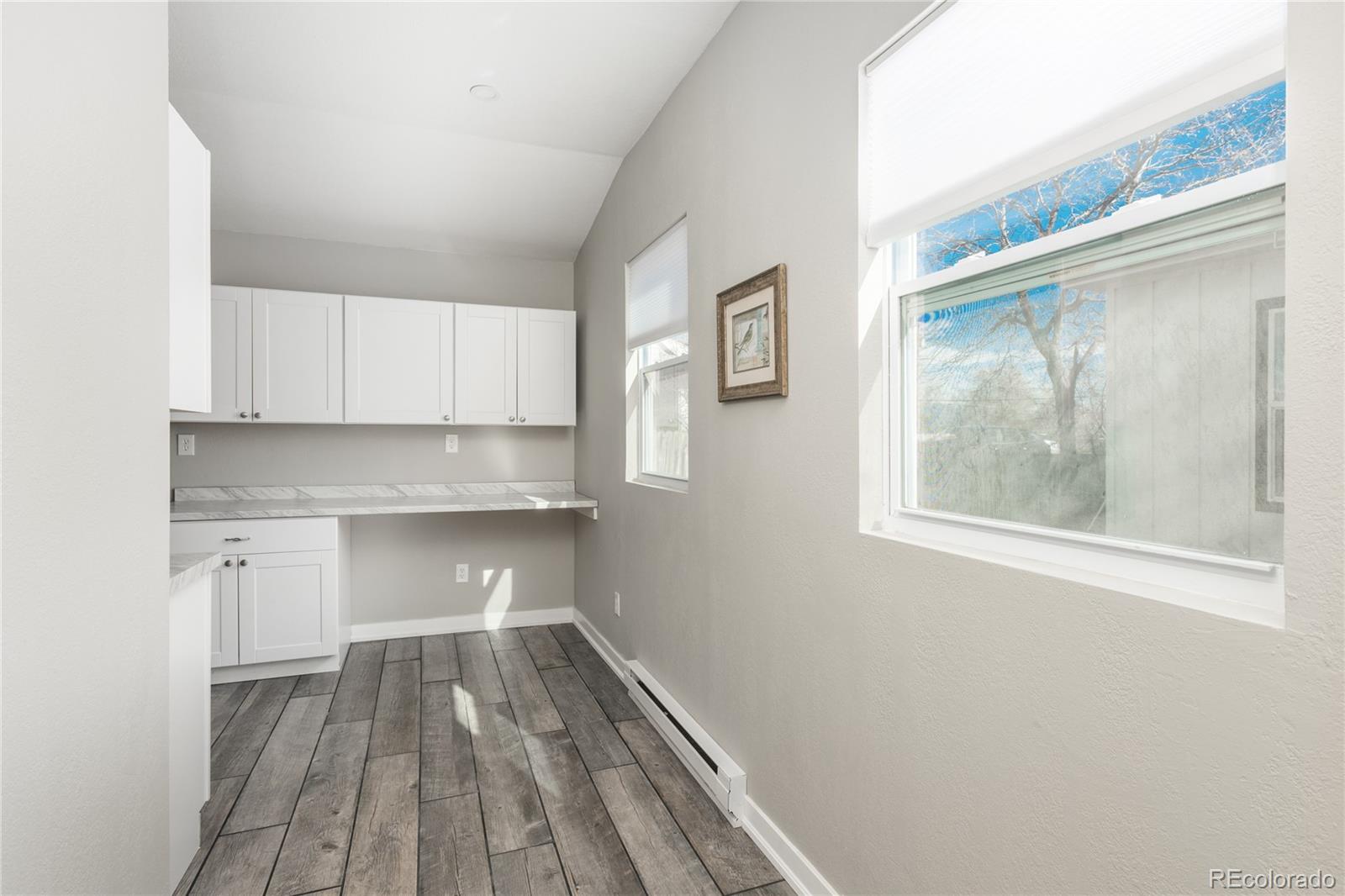 4695 Parfet Street Wheat Ridge, CO 80033 - Photo 33 of 46 a view of a kitchen with wooden floor and electronic appliances