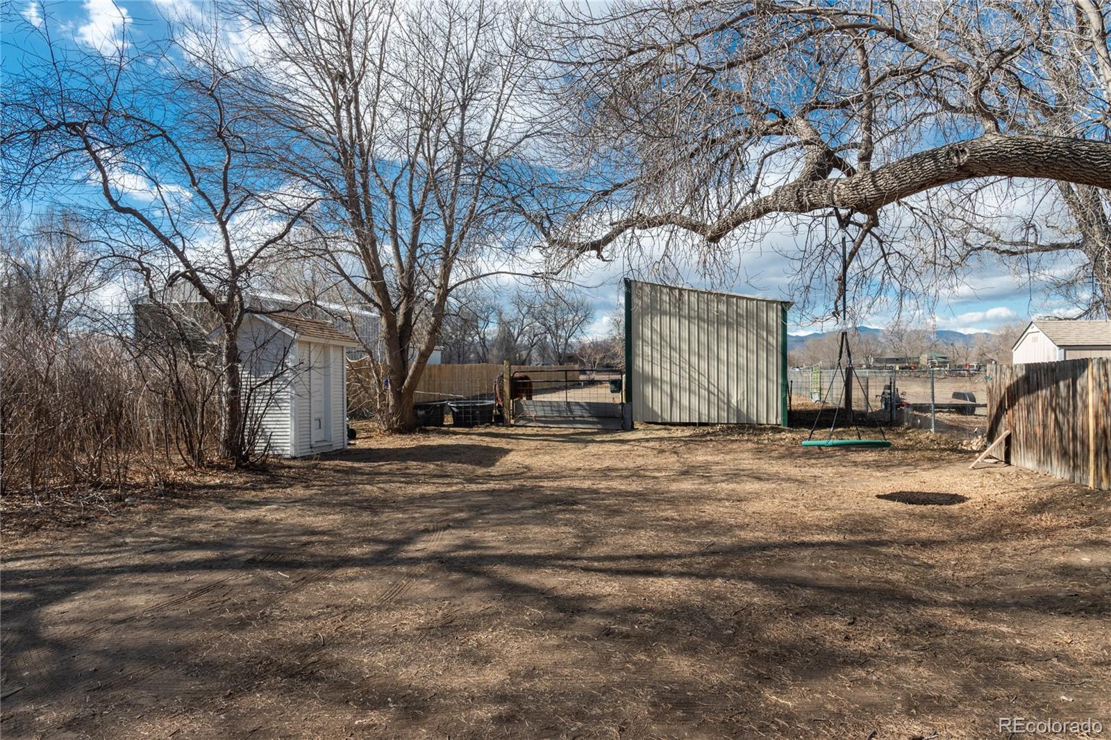 4695 Parfet Street Wheat Ridge, CO 80033 - Photo 38 of 46 a backyard of a house with large trees