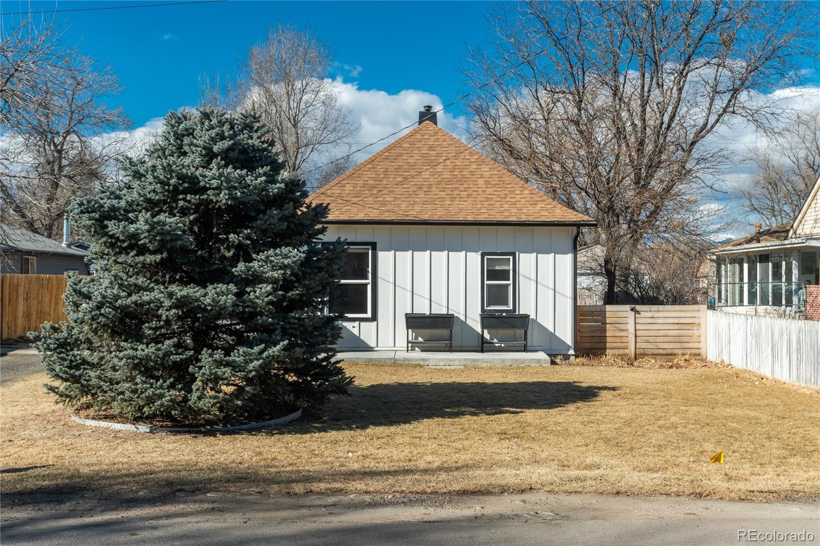 4695 Parfet Street Wheat Ridge, CO 80033 - Photo 4 of 46 a front view of a house with garden