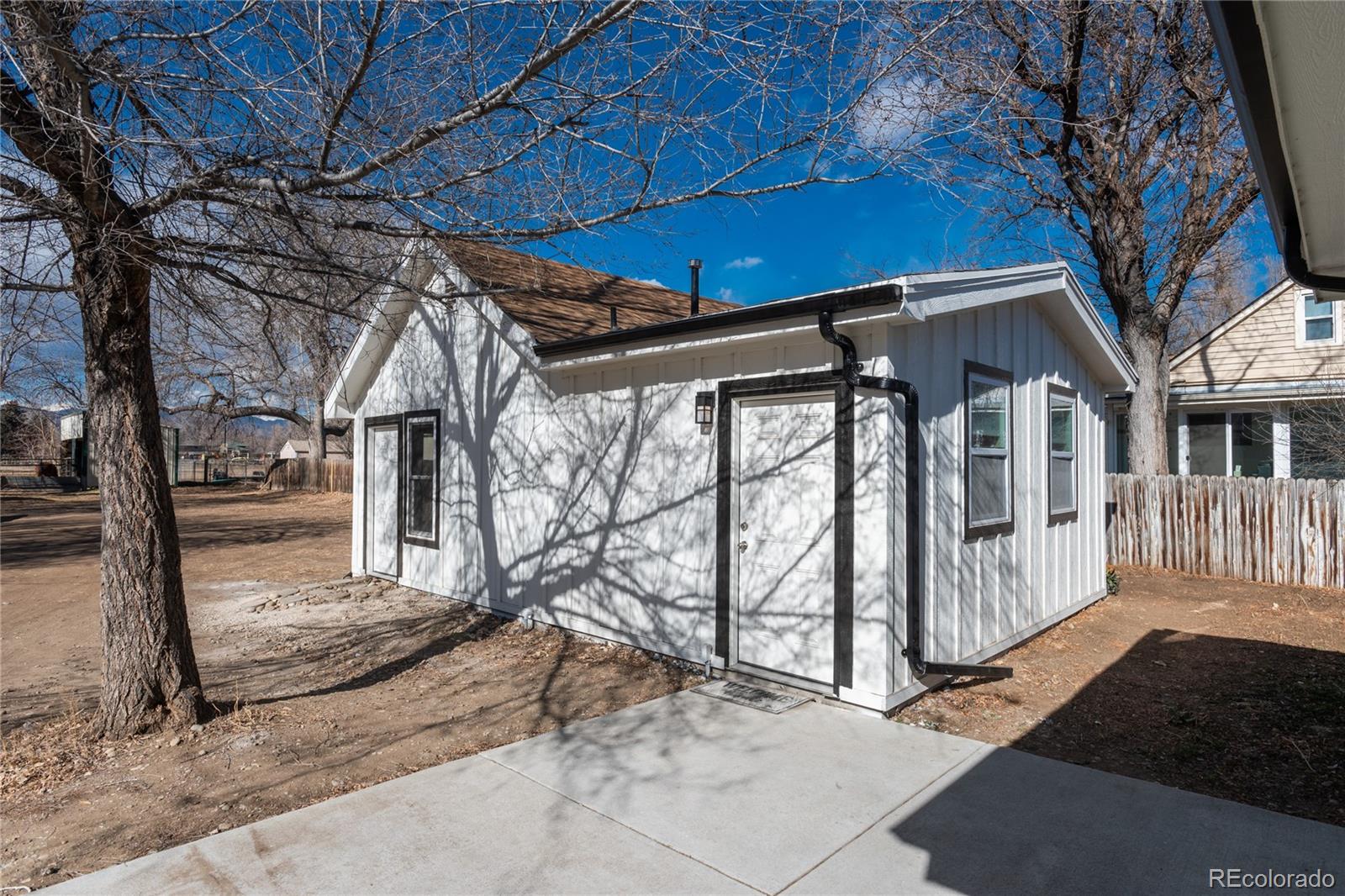4695 Parfet Street Wheat Ridge, CO 80033 - Photo 7 of 46 a view of a house with a small yard and wooden fence