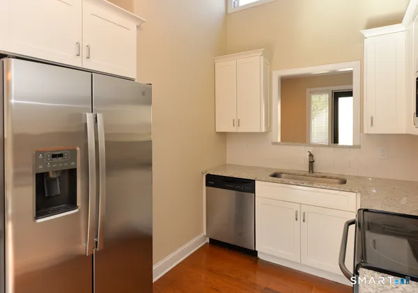 a kitchen with a refrigerator sink and cabinets