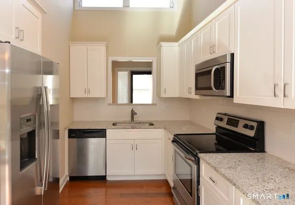 a kitchen with stainless steel appliances granite countertop a refrigerator sink and microwave