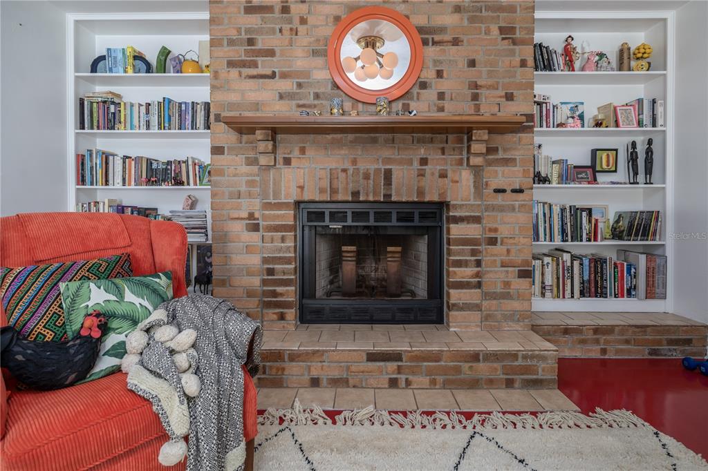 4790 Michael Lane Ponce Inlet, FL 32127 - Photo 18 of 28 a living room with a bookshelf and a fireplace