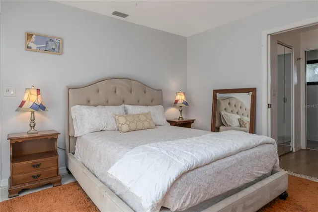 a bedroom with a bed and a lamp on table