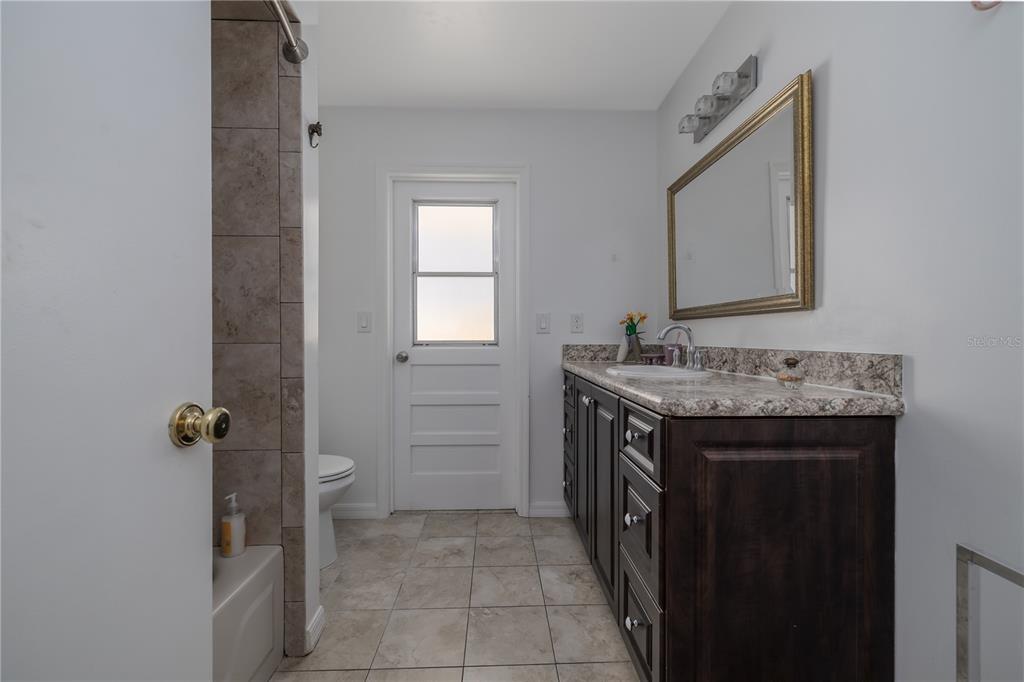4790 Michael Lane Ponce Inlet, FL 32127 - Photo 24 of 28 a bathroom with a granite countertop sink and a mirror