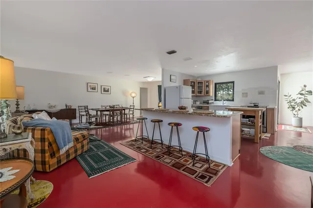 a living room with furniture a rug and kitchen view