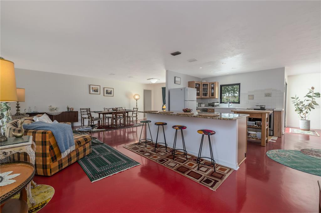 4790 Michael Lane Ponce Inlet, FL 32127 - Photo 7 of 28 a living room with furniture a rug and kitchen view