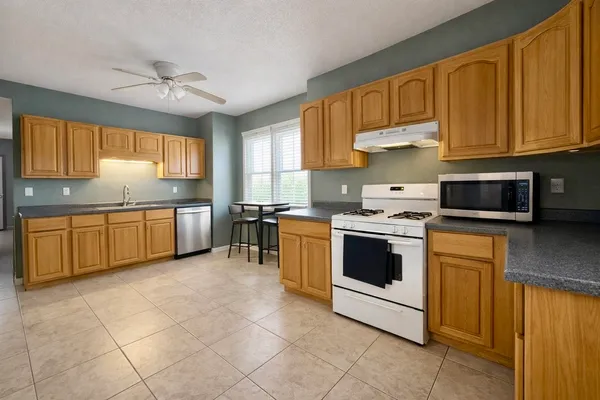 a kitchen with a stove sink and cabinets