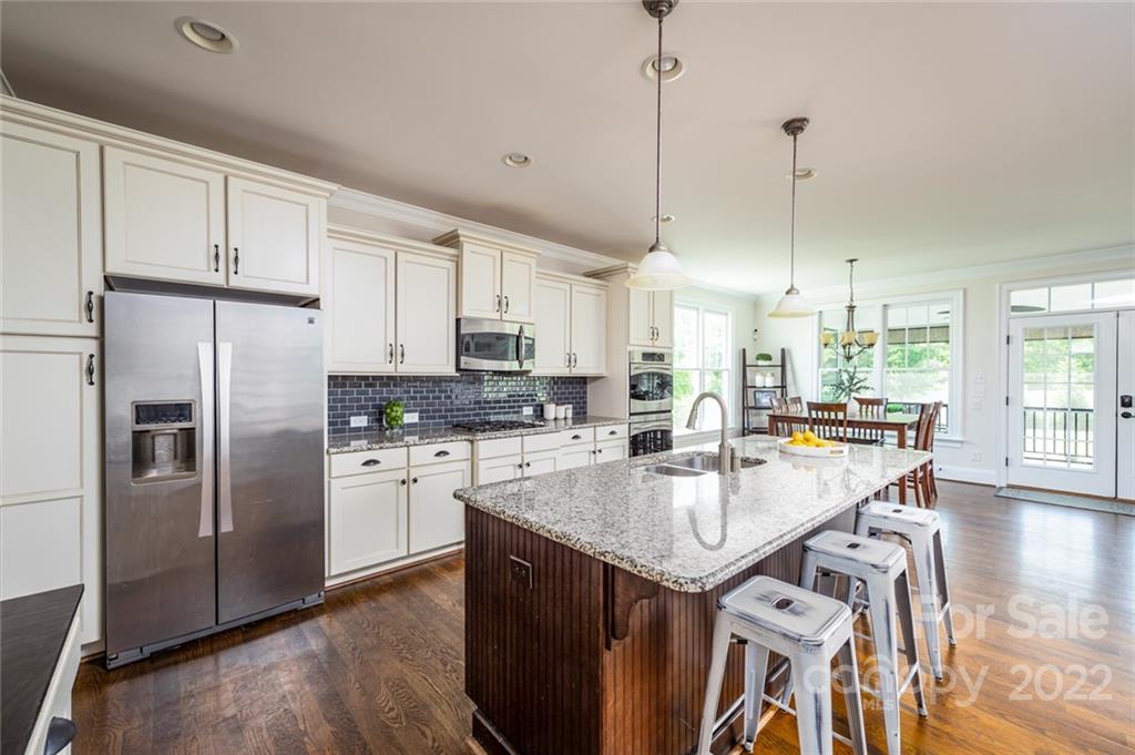 6009 Daphne Circle Fort Mill, SC 29708 - Photo 6 of 43 a kitchen with stainless steel appliances granite countertop a refrigerator a sink dishwasher a stove and white cabinets with wooden floor