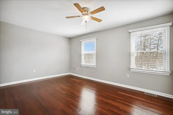 a view of an empty room with window and a fan