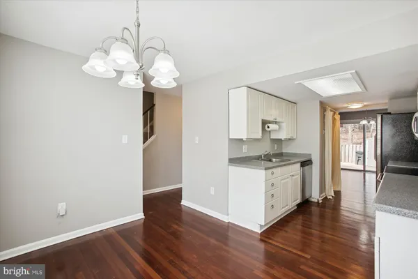 a kitchen with a chandelier and wooden floor