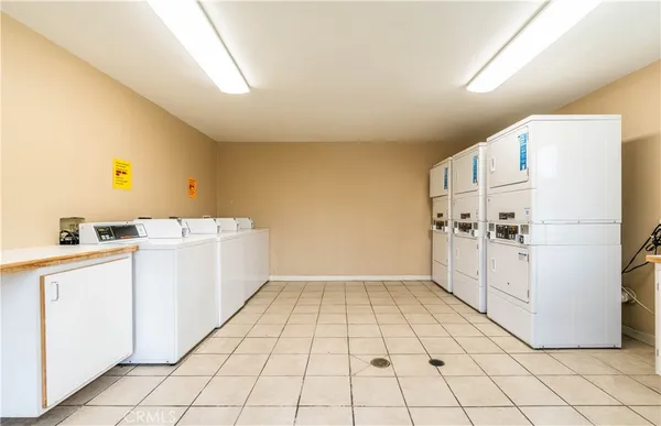 a large white kitchen with a stove a sink dishwasher and a refrigerator with white cabinets