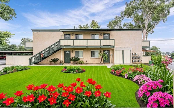 a front view of a house with a big yard and potted plants