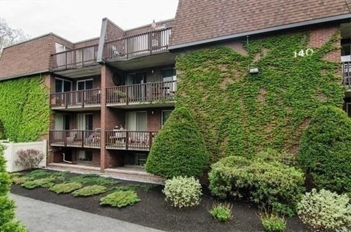 140 Kenrick Street, Unit 25 Boston, MA 02135 - Photo 12 of 12 a view of a house with a plants and a large tree