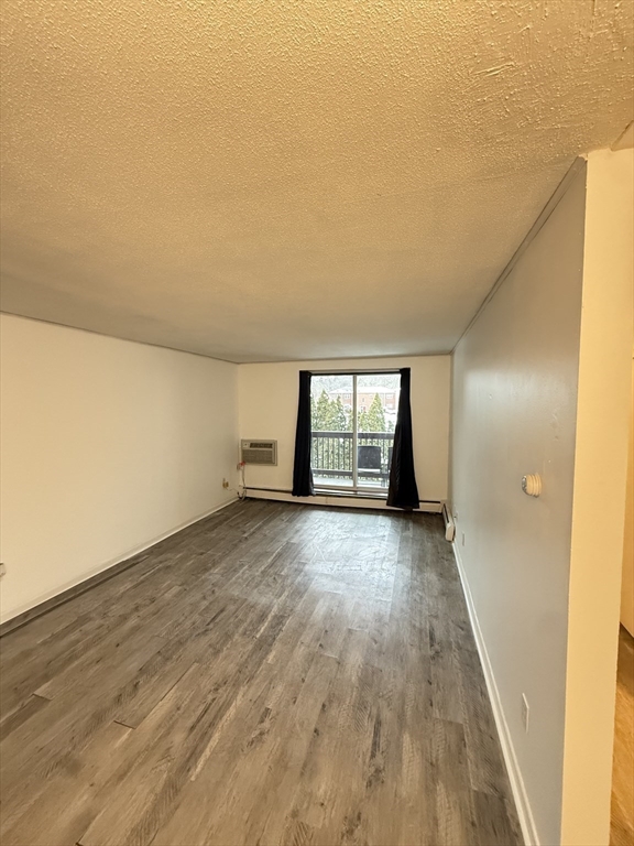 140 Kenrick Street, Unit 25 Boston, MA 02135 - Photo 4 of 12 wooden floor in an empty room with a window