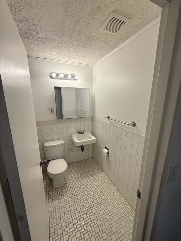 140 Kenrick Street, Unit 25 Boston, MA 02135 - Photo 6 of 12 a bathroom with a sink and a mirror