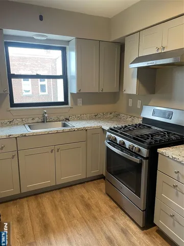 a kitchen with granite countertop a stove a sink and a microwave