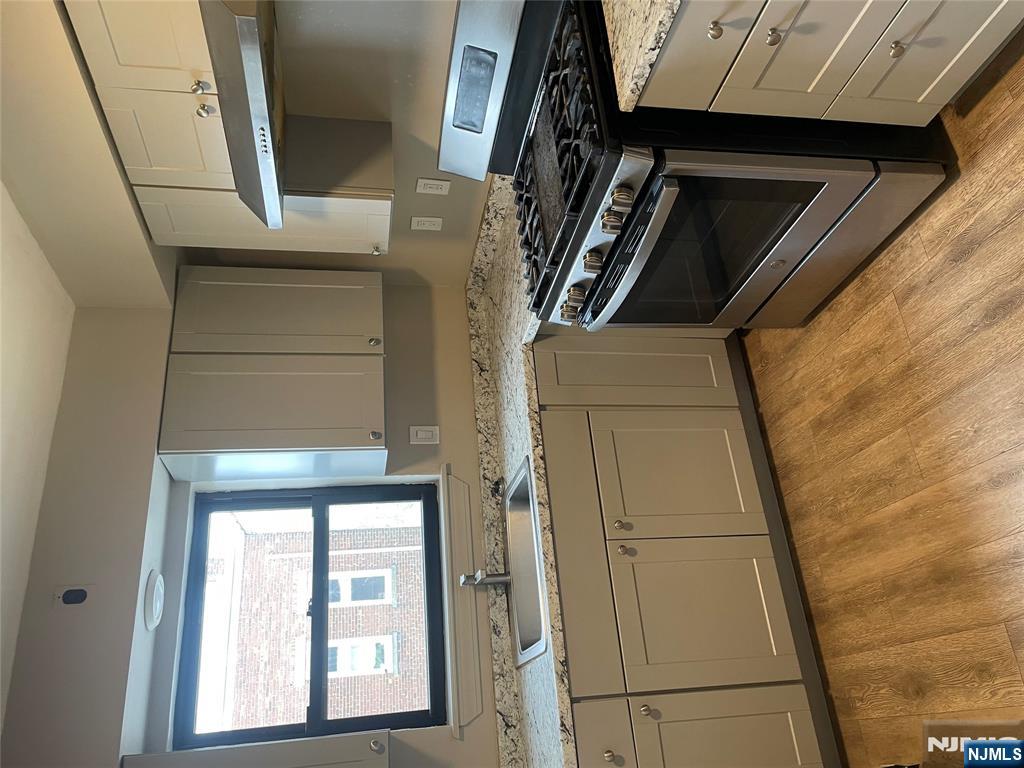 232-230 Anderson Avenue, Unit 3A Fairview, NJ 07022 - Photo 1 of 11 a kitchen with granite countertop a stove a sink and a microwave